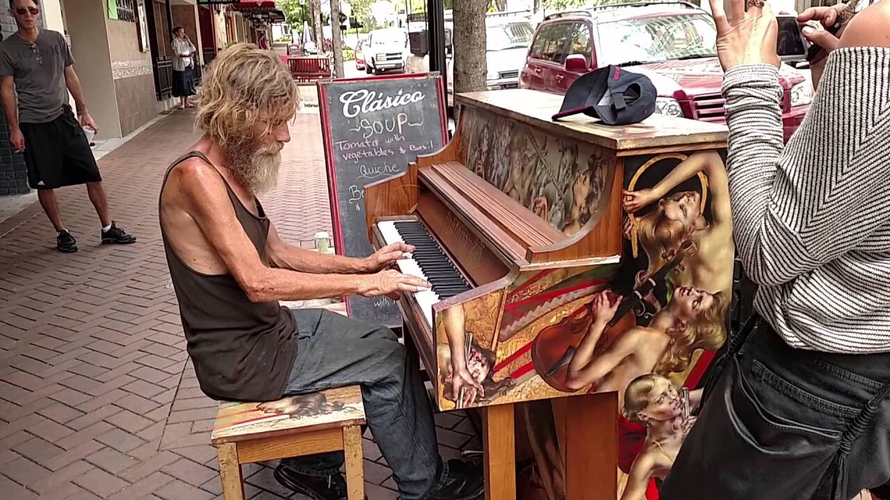 A man is playing a good piano on the street.